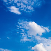 a person is flying a kite in a blue sky